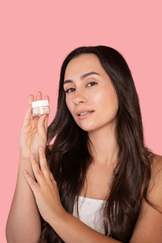 Model s blistavom kožom drži Maleena Awaken Eye Cream – prirodnu kremu za područje oko očiju s fermentiranom malinom.