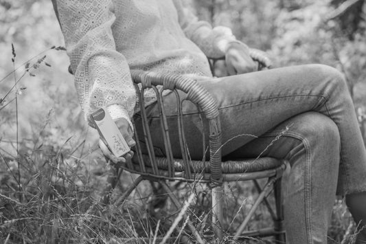 Opušten trenutak u prirodi uz Maleena skincare proizvod u ruci.