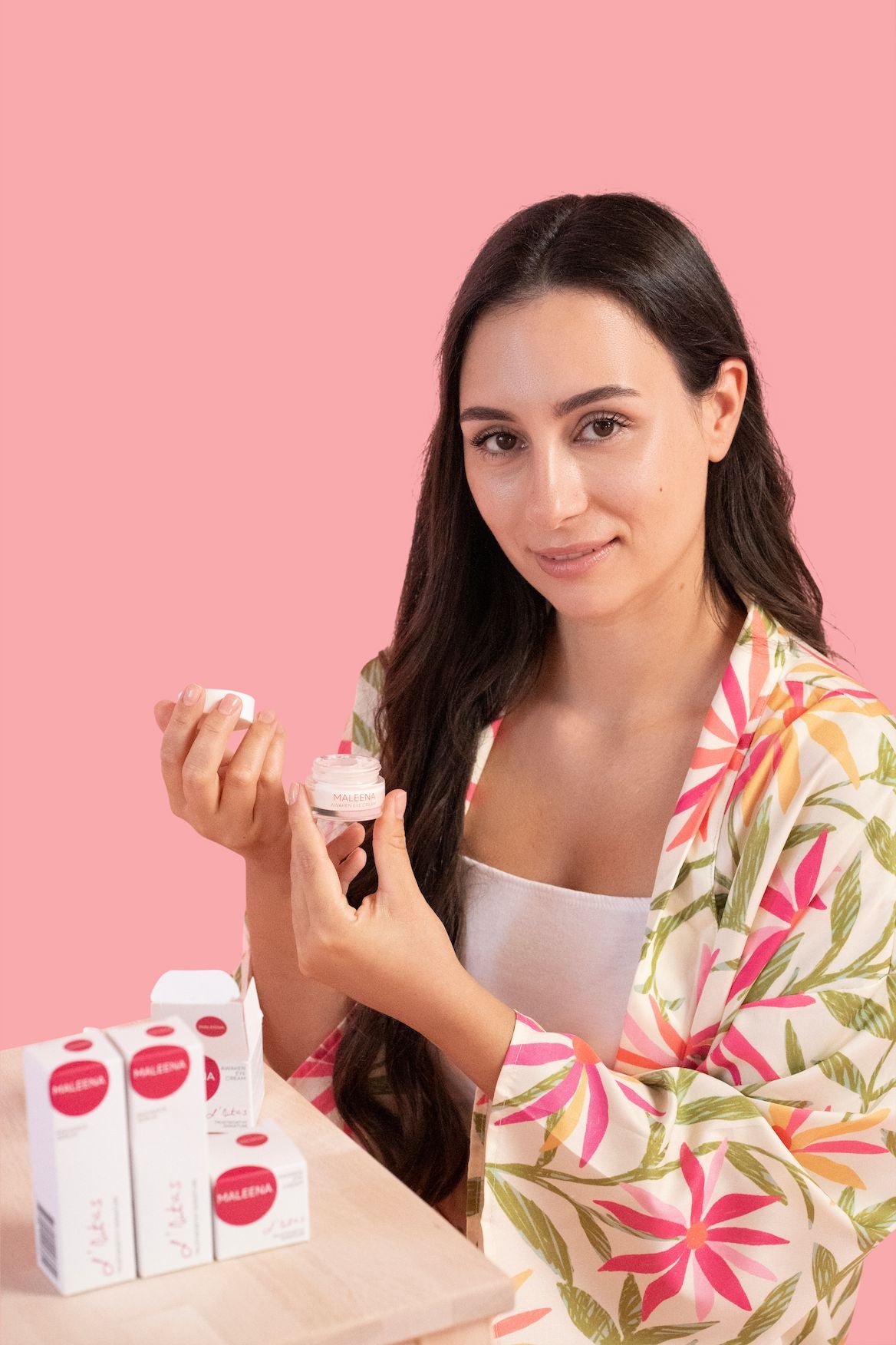 Model nanosi Maleena Awaken Eye Cream uz stol s proizvodima – trenutak holističke njege i clean beauty rituala za zdravu, blistavu kožu.