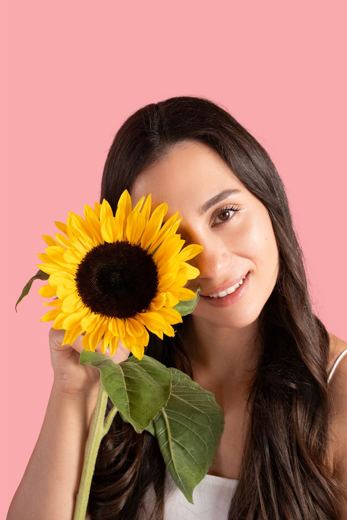 Model s toplim osmijehom drži suncokret – simbol svjetlosti, prirode i pozitivne energije koju donosi Maleena clean beauty s fermentiranom malinom.